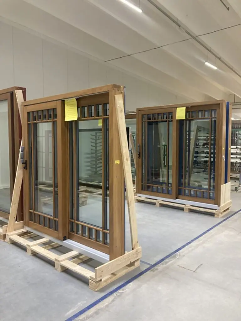 Wood-framed window and door units displayed in a manufacturing facility.